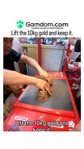 buzz__decode on Instagram: "The post shares a 26-second video of a Chinese street game booth challenging passersby to lift a labeled 10kg gold bar and claim it as a prize, but participants struggle as the bar remains stuck to the table. The apparent impossibility stems from a hidden suction mechanism activated by a foot pedal under the booth, a common trick in carnival games to encourage repeated paid attempts, as noted in similar viral clips on social media. High engagement, including 240 repli