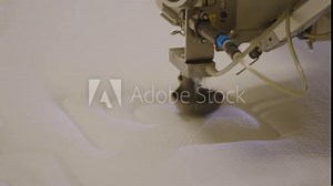 Robot arm sewing intricate patterns on a mattress in a factory, close-up Stock Video