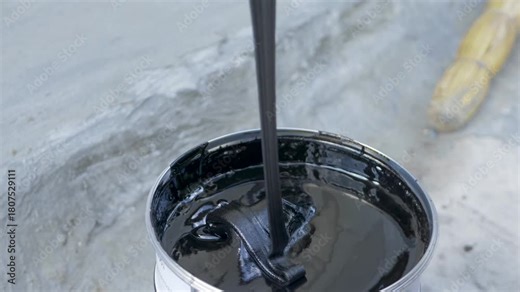Mixing bituminous waterproofing putty in a new can for use in construction. The putty is sticky and thick. It protects buildings from water. Protect residential and commercial building