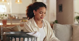 African woman, basket and fold for laundry, household work and packing in living room on sofa with smile. Female person, happy and organize clothes in house for spring cleaning, housekeeping and tidy
