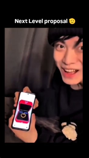 Dragon on Instagram: "The post features a short reel of a marriage proposal built entirely around a foldable smartphone gag: the screen displays a digital ring box, and when the phone snaps shut, it perfectly reveals a real ring tucked behind it. The setup turns the device itself into part of the reveal, merging tech novelty with a classic proposal moment. Its charm comes from that intersection of digital trickery and real emotion — a small theatrical twist that mirrors how modern couples mix ev