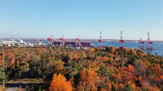 Aerial view of Halifax port in Nova Scotia, Canada. Giant cargo ship docked with cranes loading containers. Key Canadian hub for global maritime trade and export.
