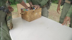 Magazines with bullets of firearm on table with military around. Authentic real scene