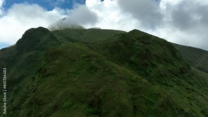 Aerial view. Clouds over the top of Mont Pelée volcano on the tropical island of Martinique. Beautiful mountain in green bushes.