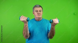 Senior man doing dumbbells exercise daily workout, lifts arms up to shoulders.