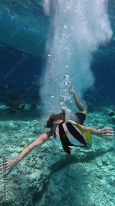 Strong male diver diving underwater and splashing the water