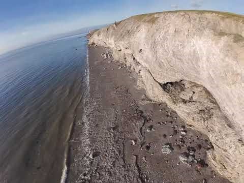 Cliffs waves and trains . Workington steel works and slag banks
