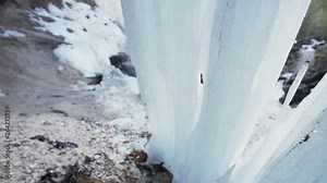 A big ice structure under a waterfall