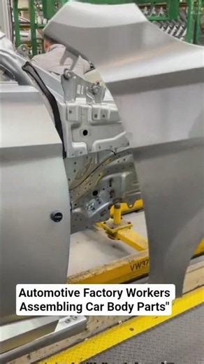 Automotive Factory Workers Assembling Car Body Parts"