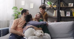 Full family having fun together on the couch. Children join parents playing smiling. Happy family. Dream childhood