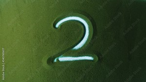 Hand drawing Number Two 2 Symbol in the Green Sand. Male hand writes a number on the green sand with backlight. It is a series from 0 to 10. Top view 4k resolution