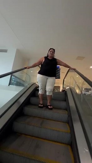 Woman Falls Backward At Escalator End