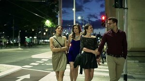 Group of people walking at night on street, steadycam shot