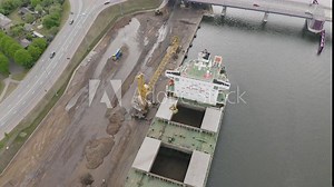 Cargo Ship Loading Multiple Shipping Containers from semi-trailer trucks
