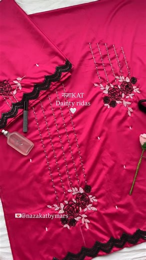 नज़ा𝐊𝐀𝐓✨ on Instagram: "Where bold meets beauty — this hot pink cotton silk Rida is adorned with delicate rose handwork, dreamy beadline detailing, and soft scattered accents. Finished with an elegant scalloped black lace border, it’s a piece that speaks in florals and flows in grace.🌷🖤 Please note: Colors may vary slightly due to camera settings. Colours and handwork can be customised. #rida #ridadesigner #mumineen #custommade #fashion #fashiondesigner #handembroidery #smartwearridas #rose