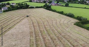 Aerial Flying Over Farmland Being Harvested For Hay In East Devon. Push Forward Shot