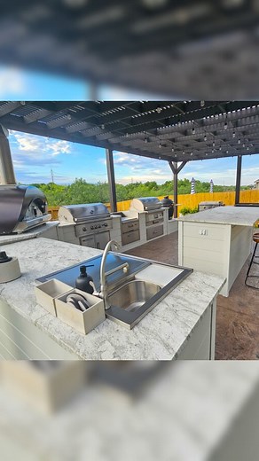RTA Outdoor Living | Outdoor Kitchens on Instagram: "Welcome to the ultimate outdoor kitchen tour! This large white plank outdoor kitchen is a showstopper, perfectly situated under a cozy covered patio. 😍 With a spacious cooking area, ample countertop prep space, AND a separate bar island, it’s the perfect setup for entertaining guests and whipping up culinary masterpieces. 🍹🔥 From hosting parties to relaxing evenings, this space truly does it all. 🌟 Built with quality & durable materials, t