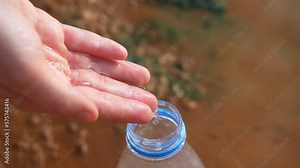 clean water in plastic bottle, dry land on the background. cracked soil, drought, water scarcity. climate change and water crisis concept, metaphor, save water. dirty rivers and lakes
