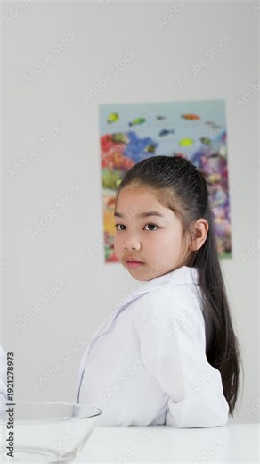 Young Asian Girl in Lab Coat Posing During Science Class