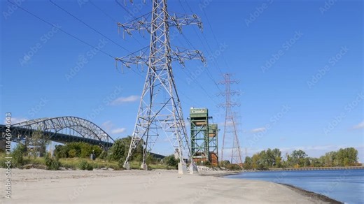 Hamilton, Ontario along the shores of Lake Ontario. The Burlington Skyway, Burlington Canal Lift Bridge and lighthouse as well as pylons carrying hydro-electricity from Niagara Falls.
