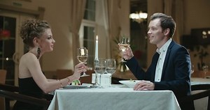 young couple with a glass of wine in the restaurant is celebrating a wedding anniversary