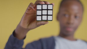 Studio Portrait Of Young Boy On ASD Spectrum Solving Puzzle Cube On Yellow Background 6 | Free Stock Video Footage