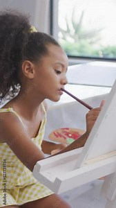 Video of focused diverse girls painting during art lessons at school