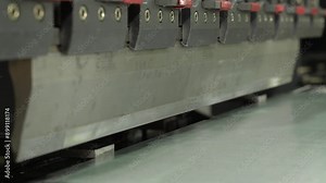 The employee hands are not bending the large parts of the metal on the bending machine, closeup. The CNC operator bending a metal product bends.