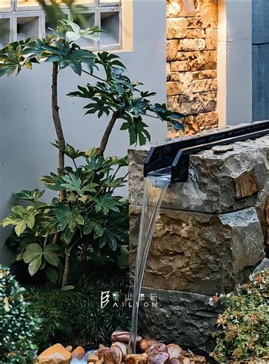As water cascades down the metal eaves, breaking through the heaviness of the stone wall, the cascading water feature becomes the most dynamic art installation in the space. Constructed from natural stone, each stone's texture bears the marks of time; water pours from custom-made metal channels, each drop a dynamic aesthetic line. With pebbles as its base and greenery as its backdrop, the fluidity of water, the stability of stone, and the vibrancy of plants blend together, creating an ultimate d