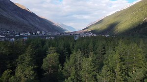 Valley embraced by mountains and forests seen from above
