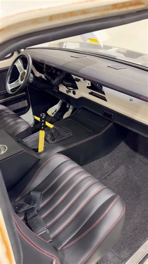 Getting these center consoles to fit right in a bumpside takes some serious work. This one came out clean though. Laser cut and wrapped in black leather with racing red stitching. Cup holders, storage, armrest, all the essentials. Really like how the sporty look works with the patina on this truck. The rest of the interior kit is looking beautiful in there! | Dave’s Auto Upholstery