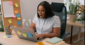 angry upset shocked Afrcan American woman using laptop in home office frustrated mad confused with computer problem, girl shrugging shoulders with raised hands Female delite files, projects by mistake