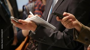 Group of unrecognizable journalists record interviews on dictaphones. Conceptual background image on theme of journalism and media.