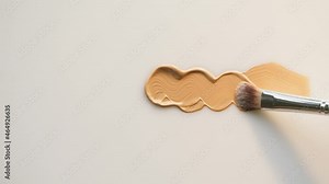 Smearing foundation tone on white background. Brown cream texture close-up, using brush. Makeup and beauty products concept, cosmetics, eyeshadow palette, bronzer or concealer.