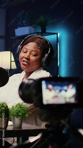 Vertical video Cheerful media stars in home studio using professional camera for internet show production on livestreaming platform. Entertainers doing podcasting session with filming equipment