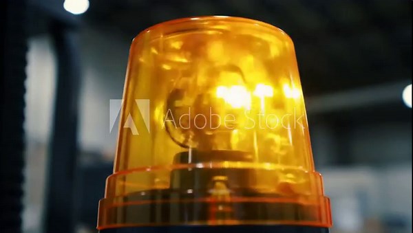Flashing amber emergency beacon light on industrial machinery. A symbol of caution, alert, and workplace safety.