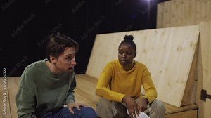 Group of diverse actors practicing emotional speech and performing play on theatre stage during rehearsal
