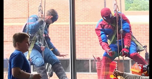 Window washers wearing superhero costumes surprise children at Iowa hospital