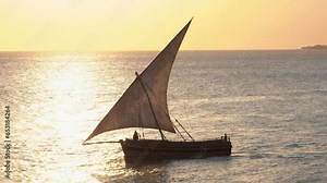 traditional commercial sailing dhow on the ocean water entering leaving harbour port heading for destinations