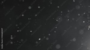 Snowflakes falling through night sky, illuminated against dark background. Winter snowfall