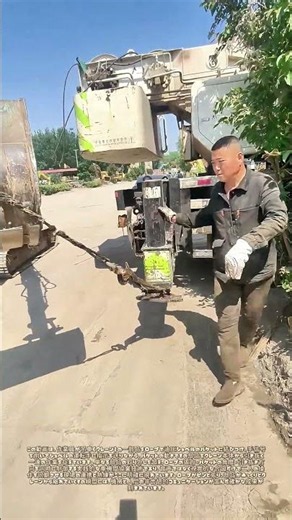 クレーンの部品をショベルのバケットに縄で繋ぎ、手信号で引き出す：重機間協業による部品取り出し