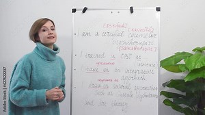 Young english teacher recording english language video, making notes on chalkboard. Online education and distance learning concept