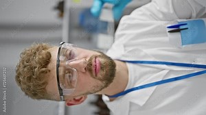 Focused scientist with beard analyzing a test strip in a laboratory setting, portraying professionalism and expertise.