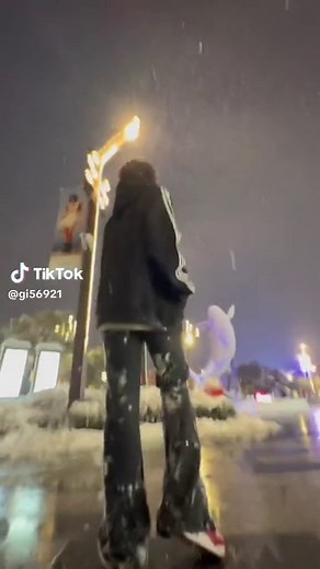 Footage of a Struggling Walker in Snowy Urban Night