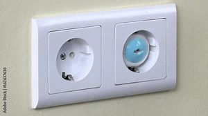 Hands install safety plugs in electricity outlet on wall Stock Video