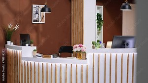 Stylish hotel reception desk and lounge area equipped with trendy extravagant decorations and lighting, providing inviting ambiance for hotel clients. Luxurious and comfy holiday getaway.