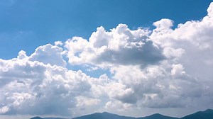 White clouds moving across a clear blue sky - Free Stock Video