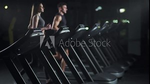 Wellness, female and man athlete run on a treadmill, two runners perform aerobic exercise and endurance training in the gym, nightlife.