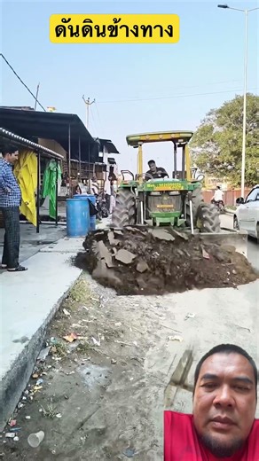 Pushing dirt along the roadside.
