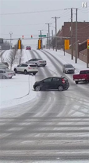 CHAIN-REACTION SLIDE ON ICY HILL SENDS CARS SPINNING THROUGH INTERSECTION December 10, 2025 – Midwest Winter Storm A security camera overlooking a busy intersection captured a chaotic sequence of crashes after a fresh layer of ice turned a steep hill into a chute that no vehicle could control. The video begins with light snow drifting across the road as a white SUV approaches the bottom of the incline. Just as it enters the intersection, its tires lose all grip—the vehicle drifts sideways, slidi